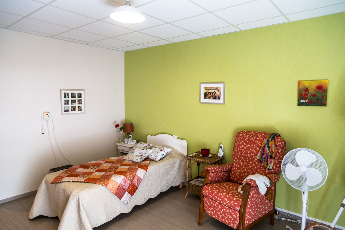 Cozy single bedroom with armchair and green wall