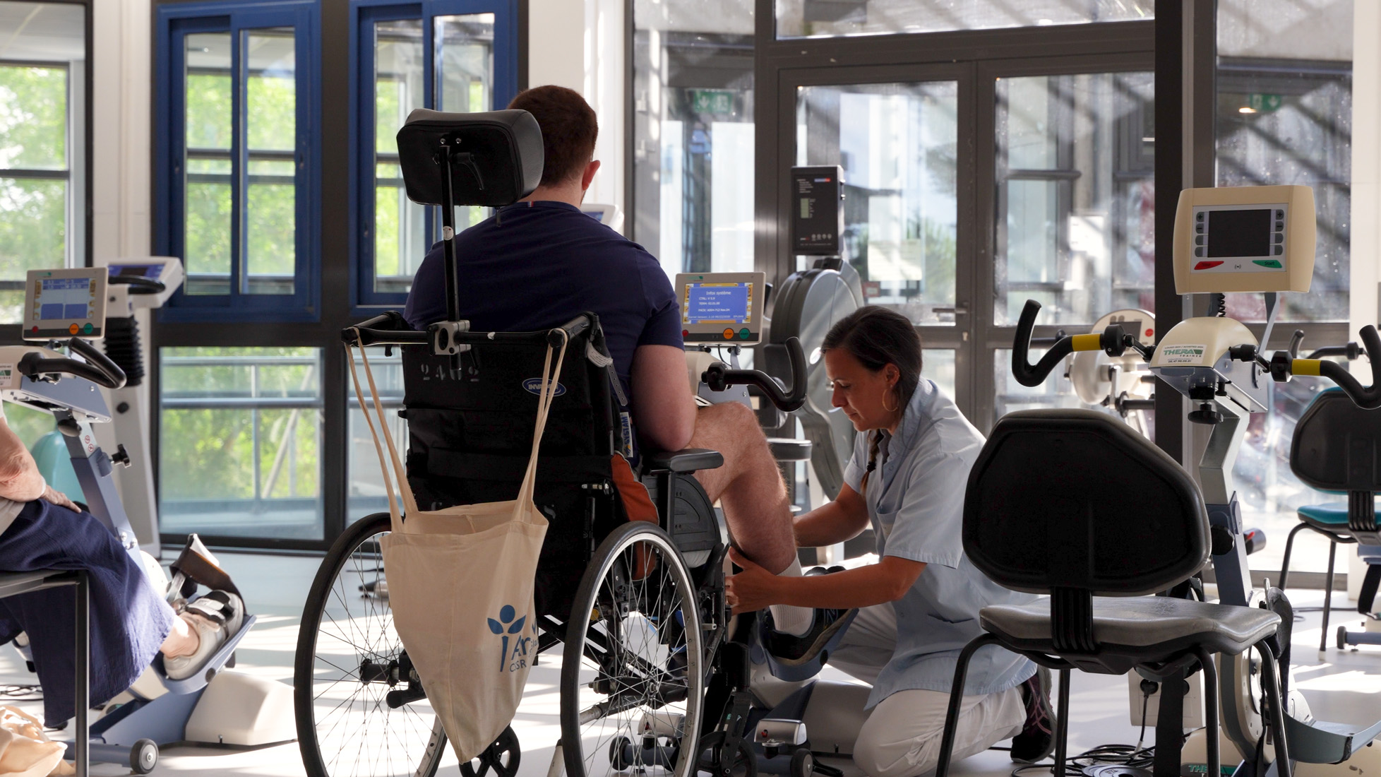 Therapist assisting wheelchair user with rehabilitation exercise