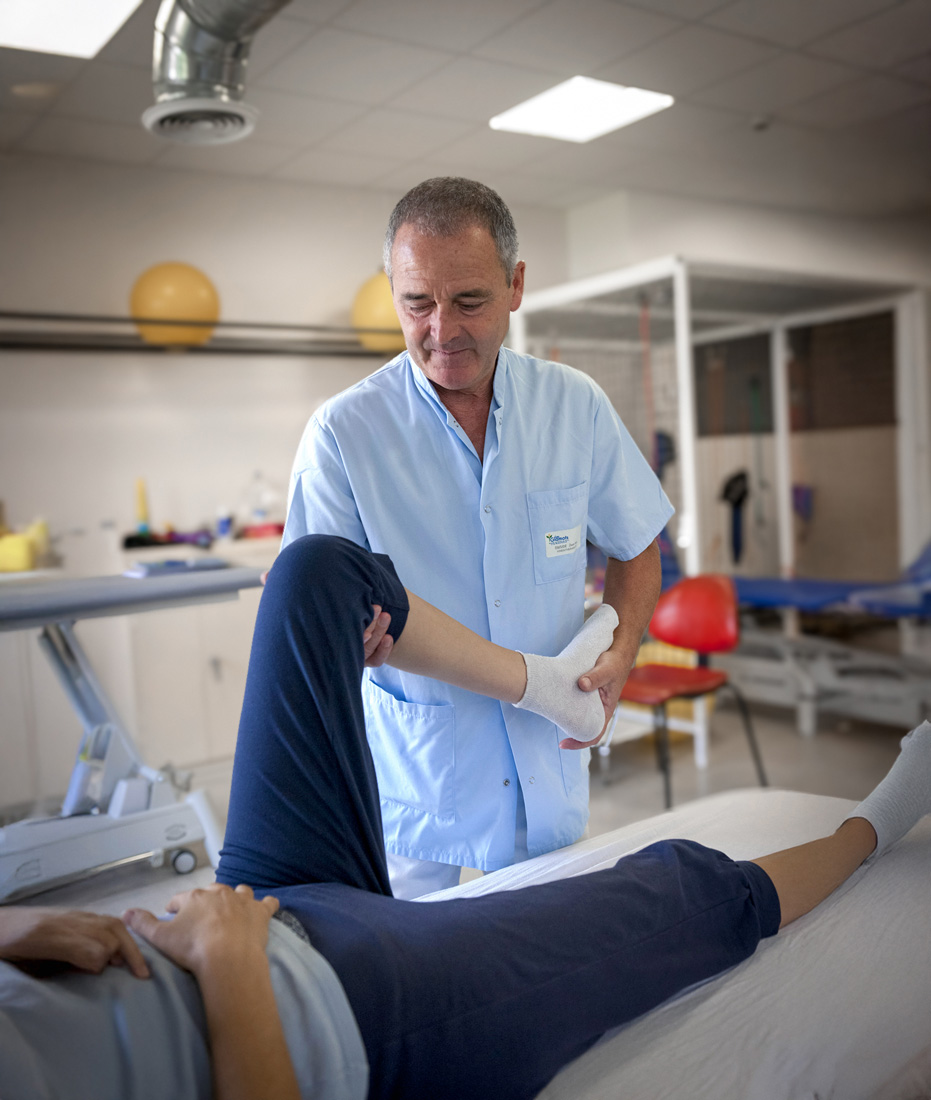Physical therapist assisting patient with leg stretch