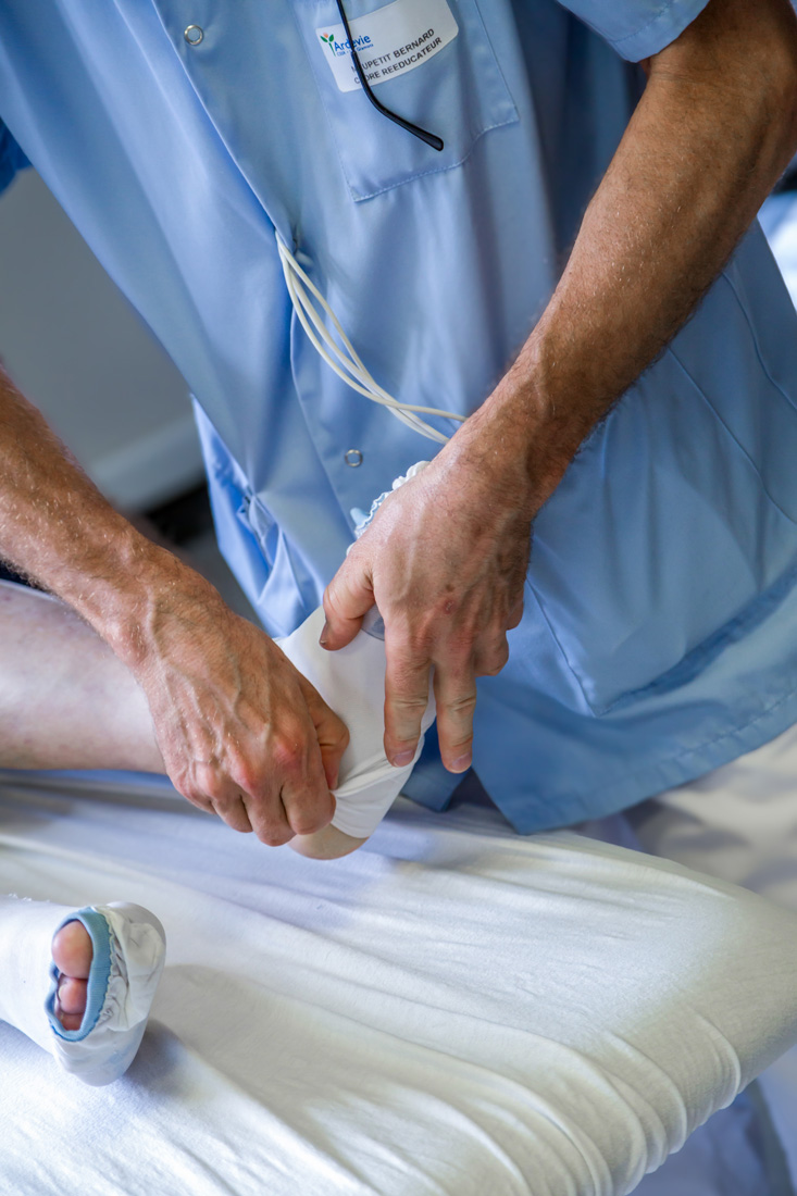 Healthcare worker adjusting bandage on patient's foot