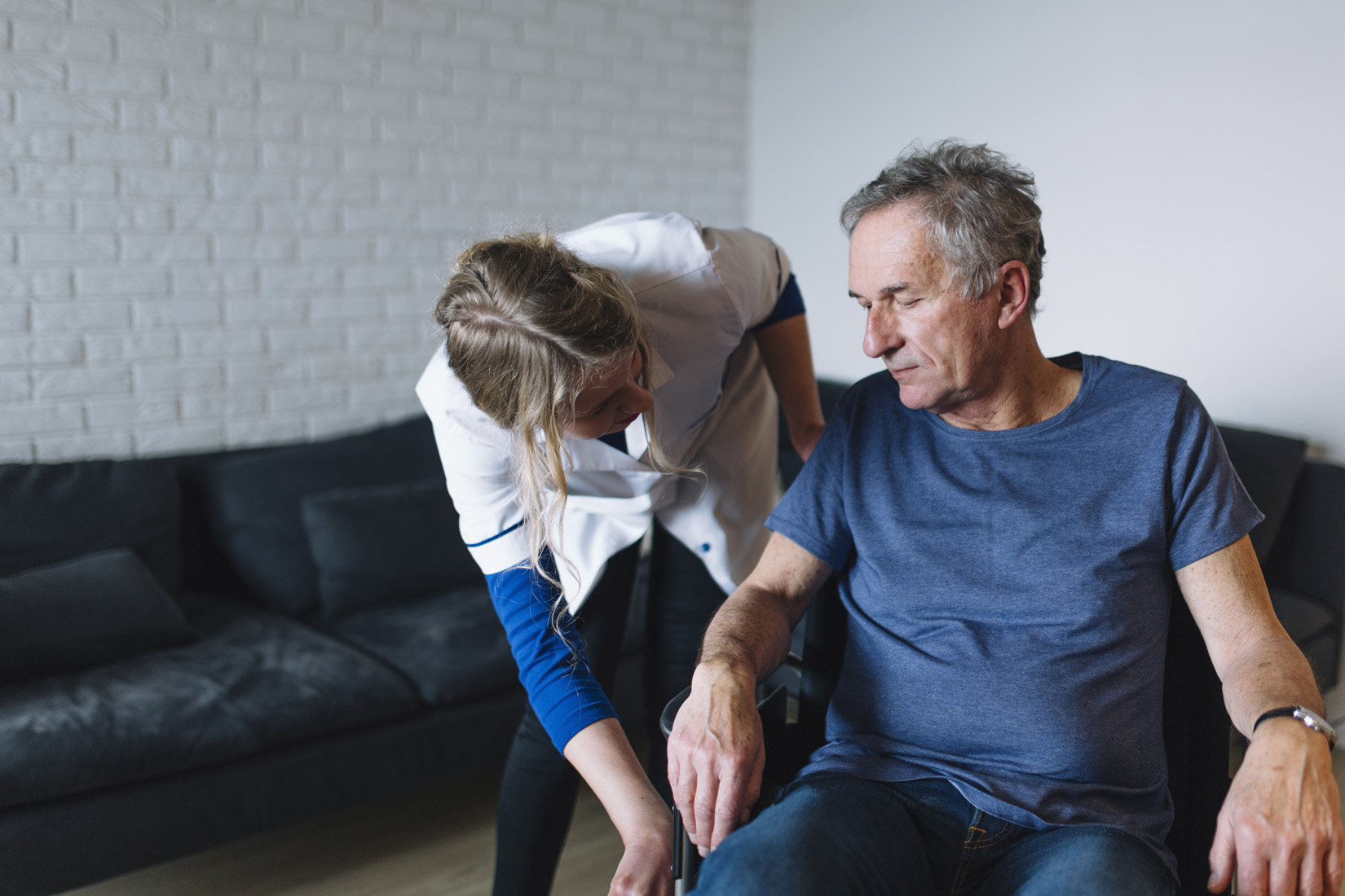 Caregiver assisting elderly man at home
