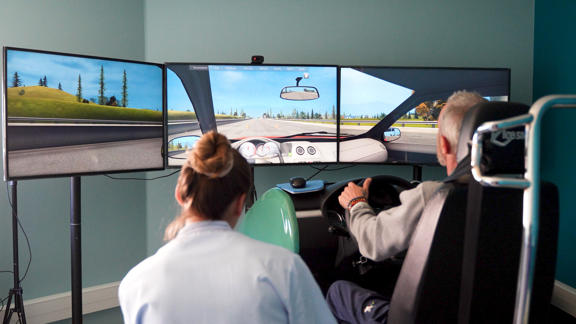 Man using triple-screen driving simulator setup
