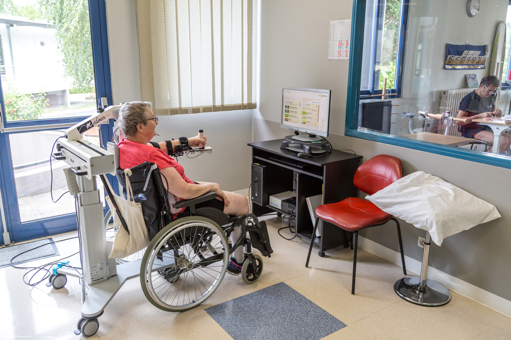 Woman in wheelchair using robotic arm therapy device