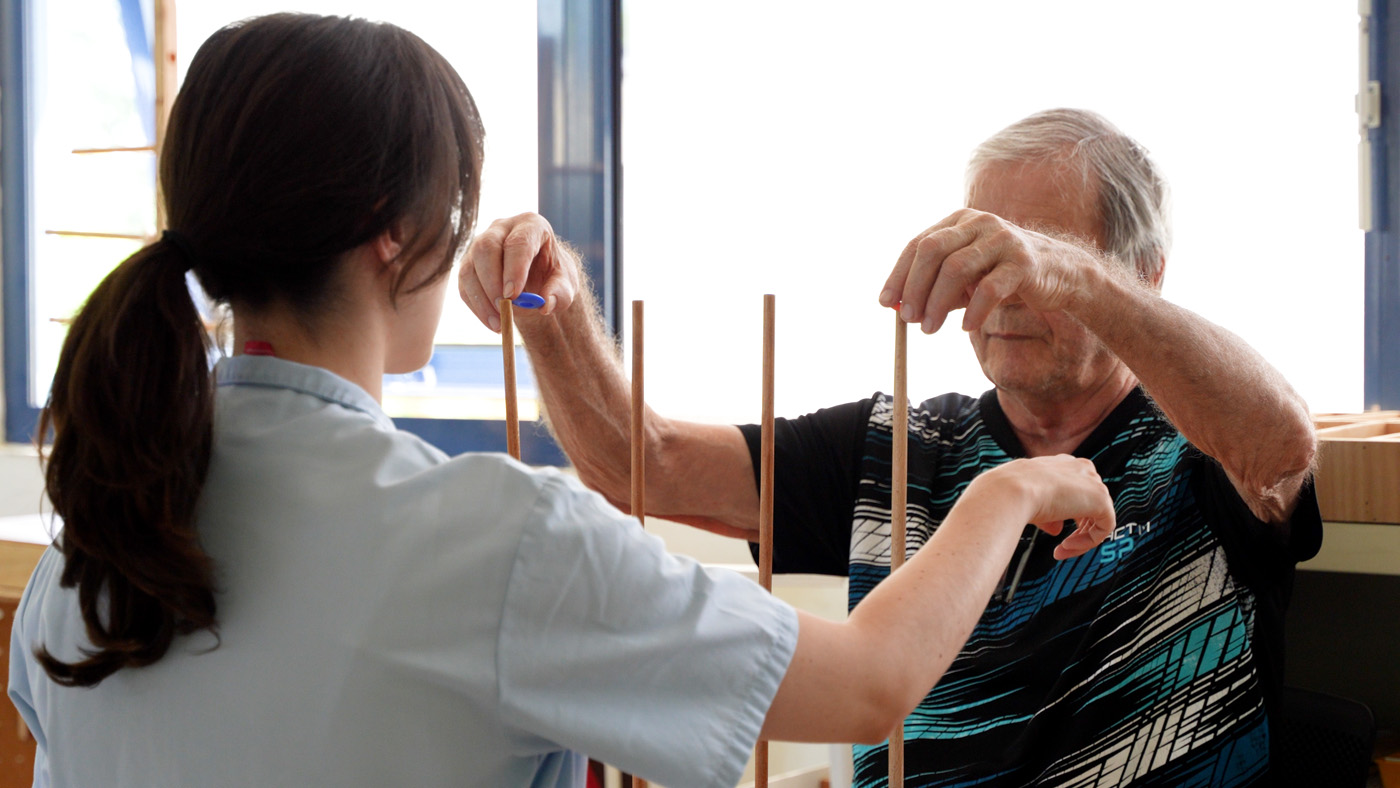 Therapist assisting senior man with hand exercise