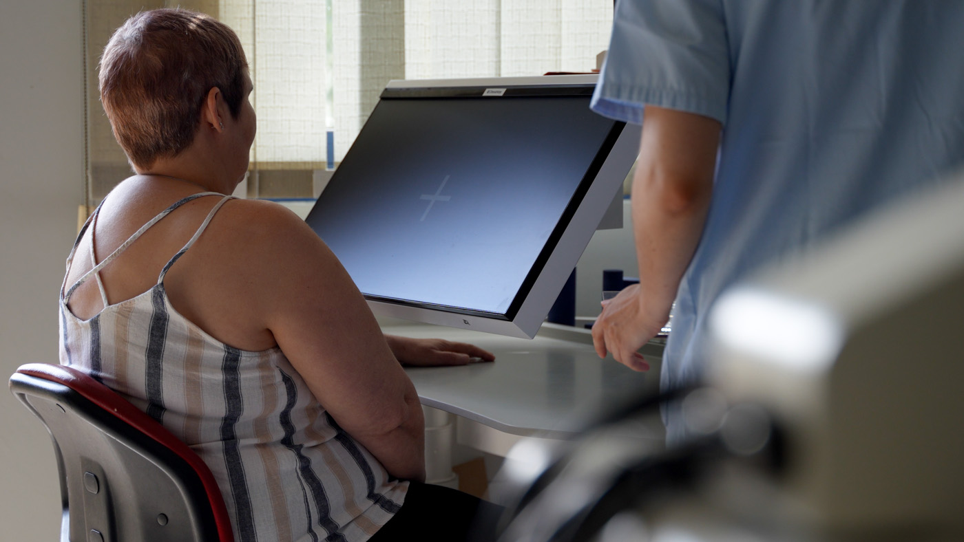 Woman undergoing medical imaging examination with technician