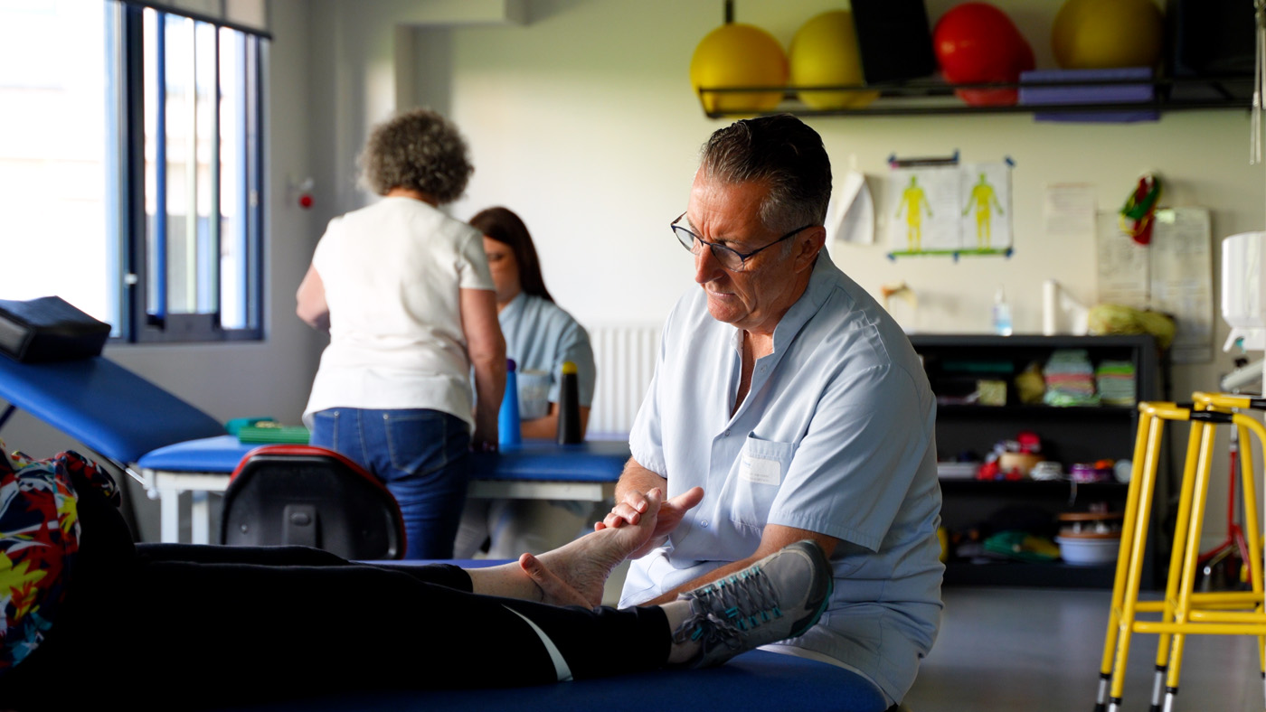 Physical therapist treating patient's foot in clinic